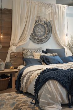 a bed with blue and white sheets, pillows and blankets on top of it in a bedroom