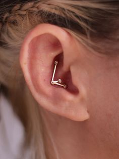 a close up of a person's ear with a small nose pin in the middle