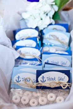 blue and white wedding favors with thank you written on them in the center of a table