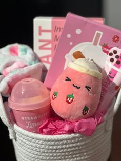 a pink stuffed animal sitting in a white basket next to a baby's bottle