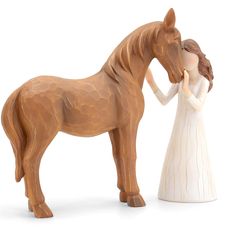 a figurine of a woman holding the hand of a horse that is standing next to it