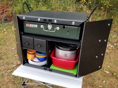 an outdoor stove with pots and pans in it