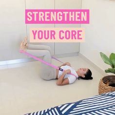 a woman laying on the floor with a pink ribbon around her waist and text overlay that reads, strength your core