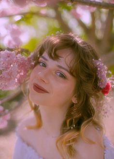 a woman with flowers in her hair looking up at the sky