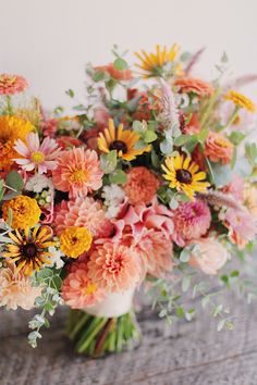 a vase filled with lots of different colored flowers