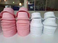 four pairs of pink and white bridal slippers are stacked on top of each other