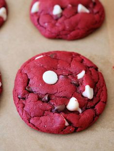 several red cookies with white chocolate chips on top