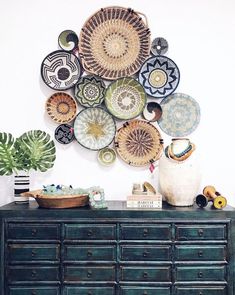 a green dresser topped with lots of plates on top of it's sideboard