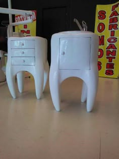 two white nightstands sitting next to each other on a table