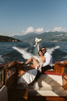 a man and woman sitting on the back of a boat