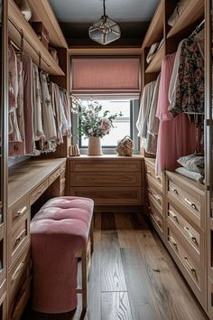 a walk in closet with lots of drawers and clothes hanging on the walls, along with a bench