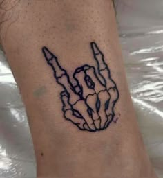 a person with a tattoo on their foot that has the shape of a hand holding two fingers