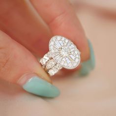 a woman's hand holding a diamond ring on top of her finger with green nails