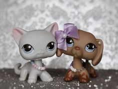 two little kittens that are next to each other on a table with silver sequins