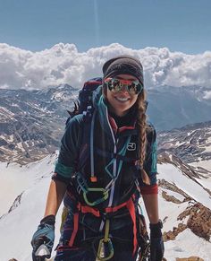 a woman standing on top of a snow covered mountain