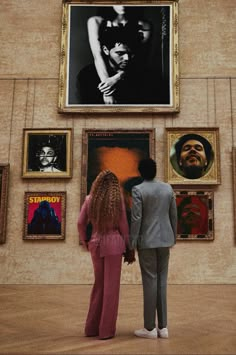 two people standing in front of an art gallery with paintings on the wall and behind them is a woman's head