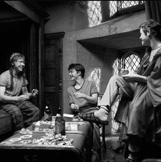 black and white photograph of three people sitting around a table