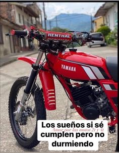 a red dirt bike parked on top of a street