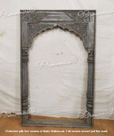 an antique fireplace surround with carved wood