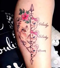 a woman's leg with tattoos on it and an arrow in the shape of two lions