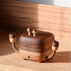 a wooden box with two little birds sitting on it's sides and the lid is open