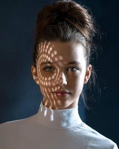 a woman is shown with the shadow of her face on top of her head and shoulders