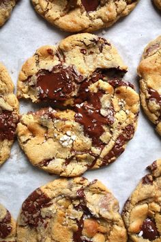 chocolate chip cookies are arranged on a sheet of parchment paper, ready to be eaten