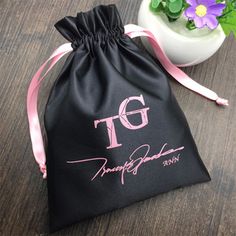 a black bag sitting on top of a wooden table next to a potted plant