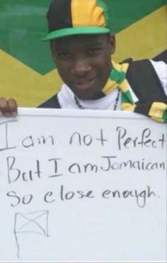 a young man holding up a sign that says i am not perfect but i am jamaican so close enough