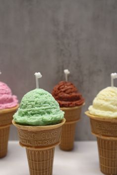 five ice cream cones with different colors and flavors on them, lined up in a row