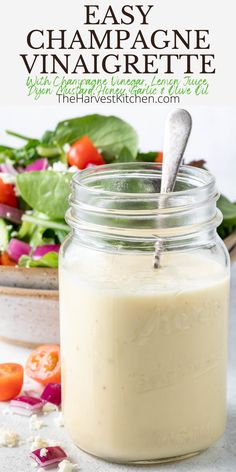 a glass jar filled with dressing next to a salad