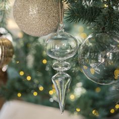 three glass ornaments hanging from a christmas tree