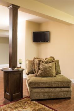 a living room filled with furniture and a flat screen tv mounted to the side of a wall