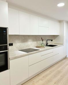 an empty kitchen with white cabinets and black stove top oven in the center, next to a sliding glass door