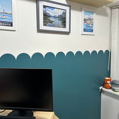 a flat screen tv sitting on top of a desk