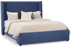 a bed with blue upholstered headboard and two pillows on top of it