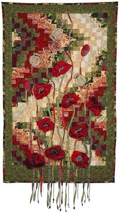 a quilted wall hanging with red flowers on it