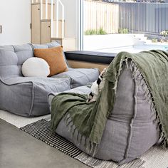 a living room filled with furniture next to a large window covered in a green blanket