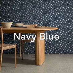 the navy blue wallpaper is next to a wooden table with two bowls on it