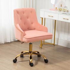 a pink office chair sitting on top of a wooden floor next to a white desk