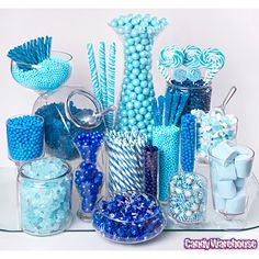 a table topped with lots of blue and white candies next to candy canes