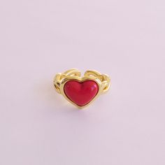 Made from delicate porcelain, this ring features a vibrant red heart-shaped centrepiece that captures the essence of love and romance. The rich, deep red hue adds a touch of warmth and passion, making it a perfect accessory for any occasion. The heart is encased in a 18K gold-plated setting and a braided band.   MATERIAL Handmade porcelain  18K Gold-plated brass    SIZE & FIT Ring size: EU 54/US 7 Ring diameter: 17. 2mm Product size: 14mm x22mmx25mm  COLOUR Red, gold  WEIGHT 6g   Handmade in Den Valentine's Day Red Heart Ring, Red Heart-shaped Ruby Ring For Valentine's Day, Red Open Ring For Valentine's Day, Red Adjustable Heart Ring For Valentine's Day, Adjustable Red Heart Ring For Valentine's Day, Enamel Heart Shaped Promise Ring, Valentine's Day Red Heart-shaped Ruby Ring, Red Heart Cut Ring, Red Heart-shaped Enamel Jewelry