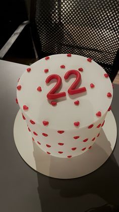 a white and red cake with hearts on the top that says 22 twenty twos