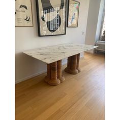 a marble table with two pillars in front of it on a hard wood flooring area