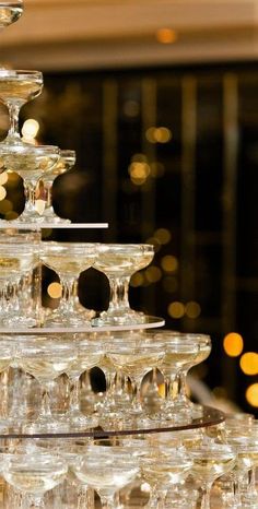 a large stack of wine glasses sitting on top of a table