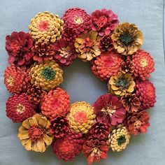 a wreath made out of pine cones and flowers