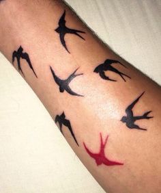 a person with a tattoo on their arm that has birds all over it