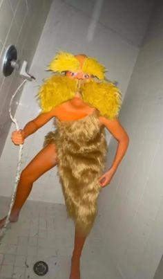 a woman in a costume is standing on the toilet with a shower head and hose