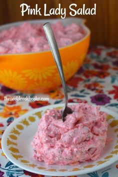 pink lady salad on a plate with a spoon in it and a bowl behind it