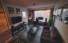 a living room filled with furniture and a flat screen tv on top of a wooden table